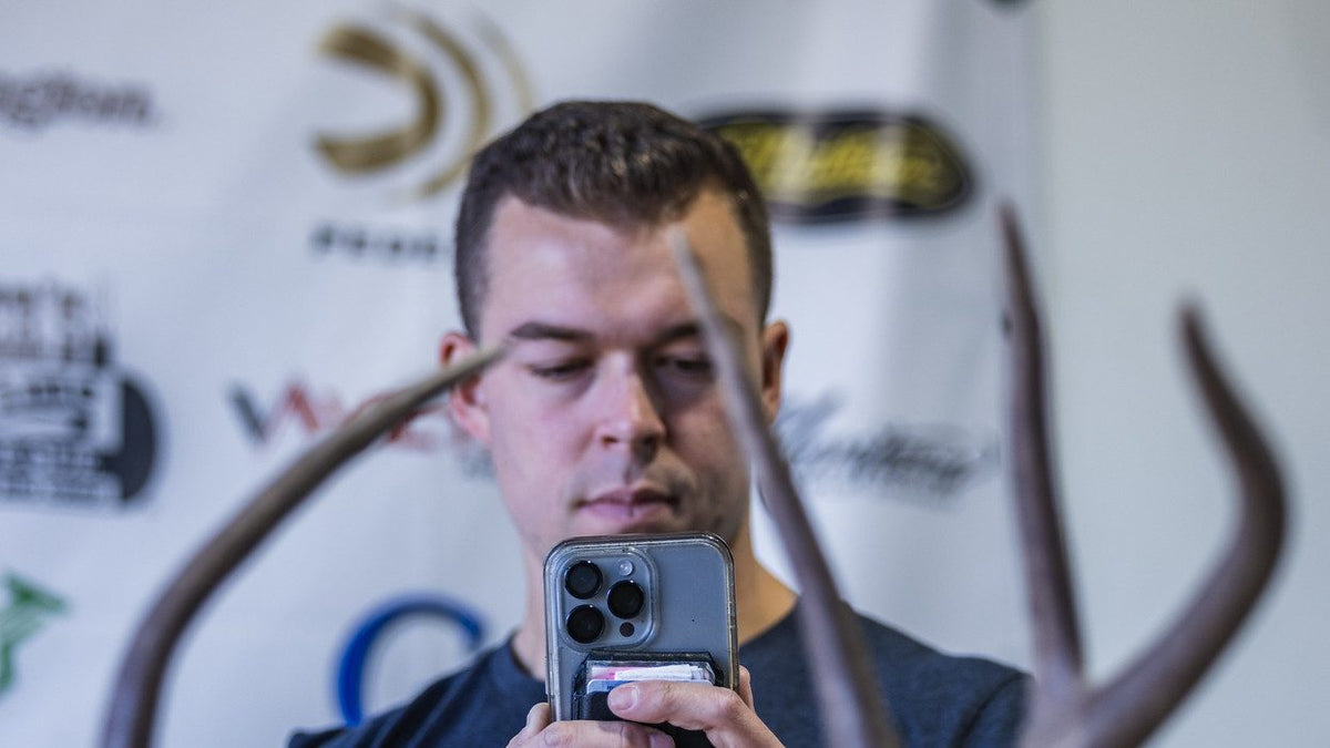 Hunter holding up his phone to scan a set of antlers
